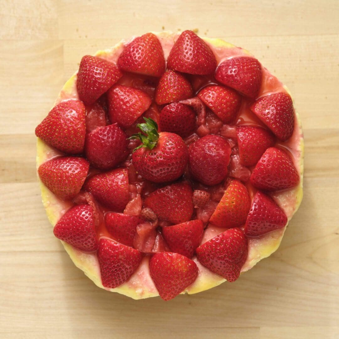 Strawberry tart on wooden surface.