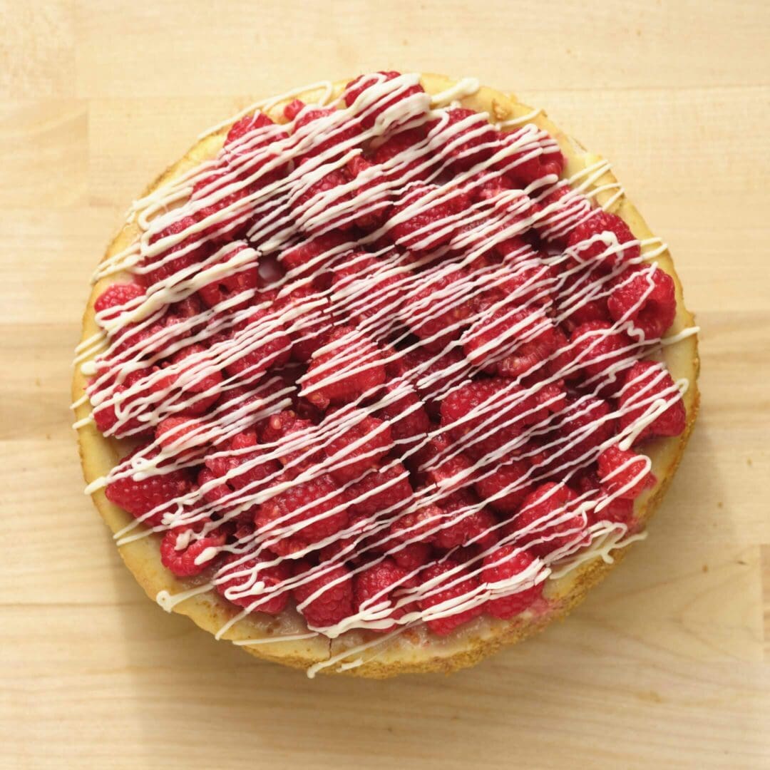 Raspberry pie with white chocolate drizzle.