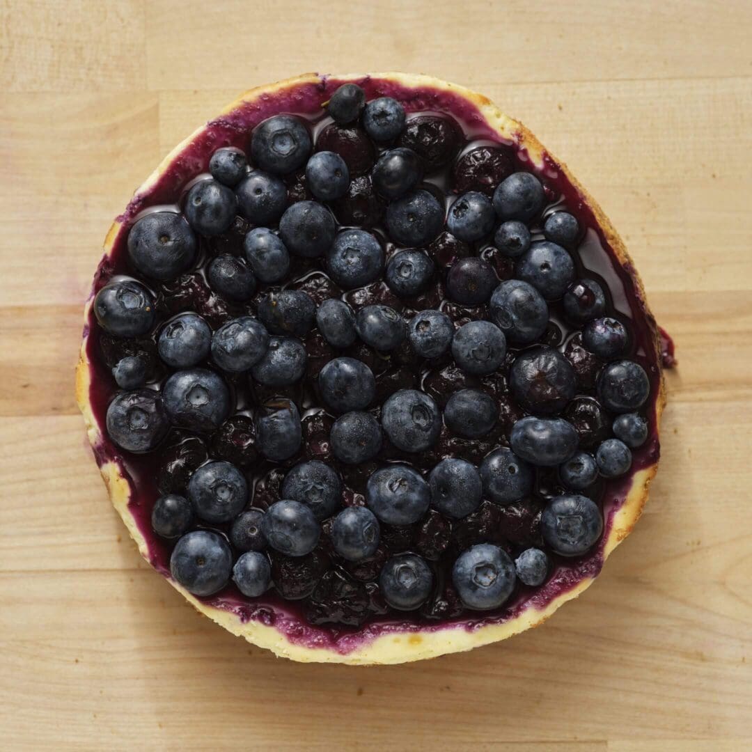 Blueberry cheesecake on wooden surface.