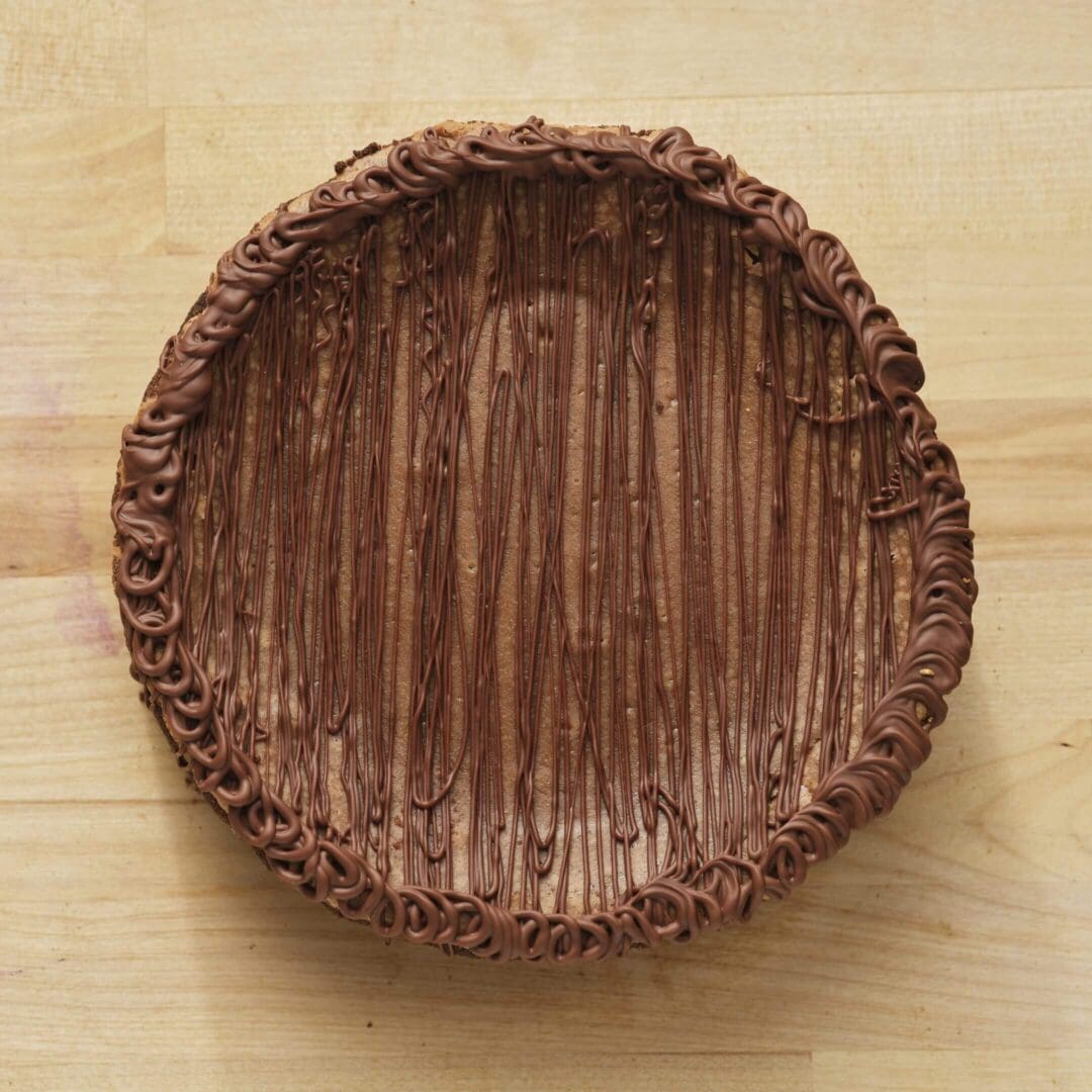 Chocolate pie with decorative frosting on top.