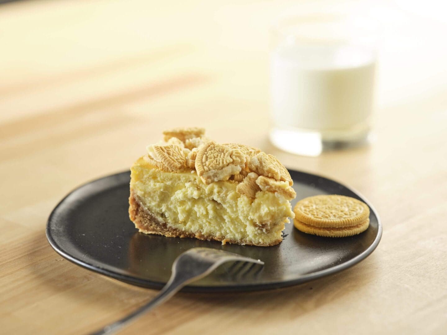 Cheesecake slice with cookies and milk.