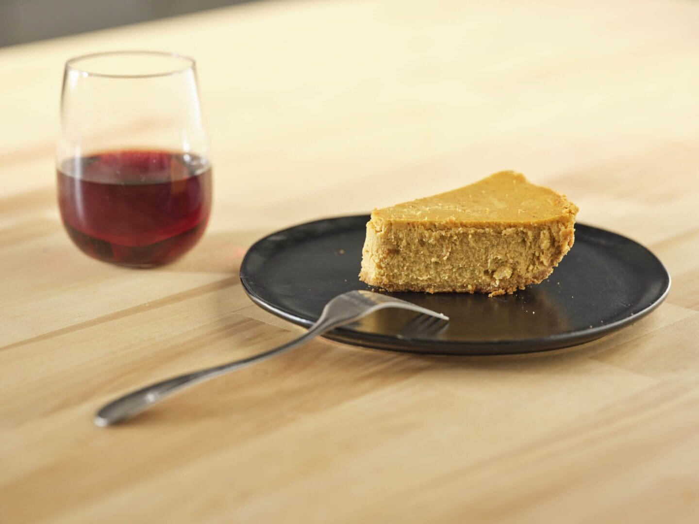 Cake slice and drink on wooden table.