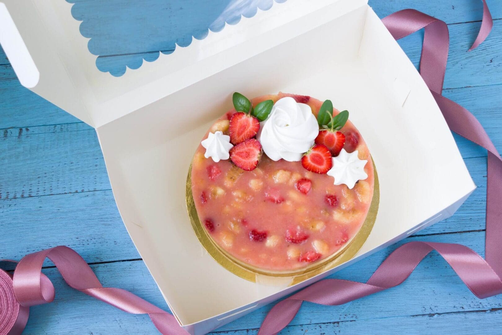 Cake with strawberries in an open box.