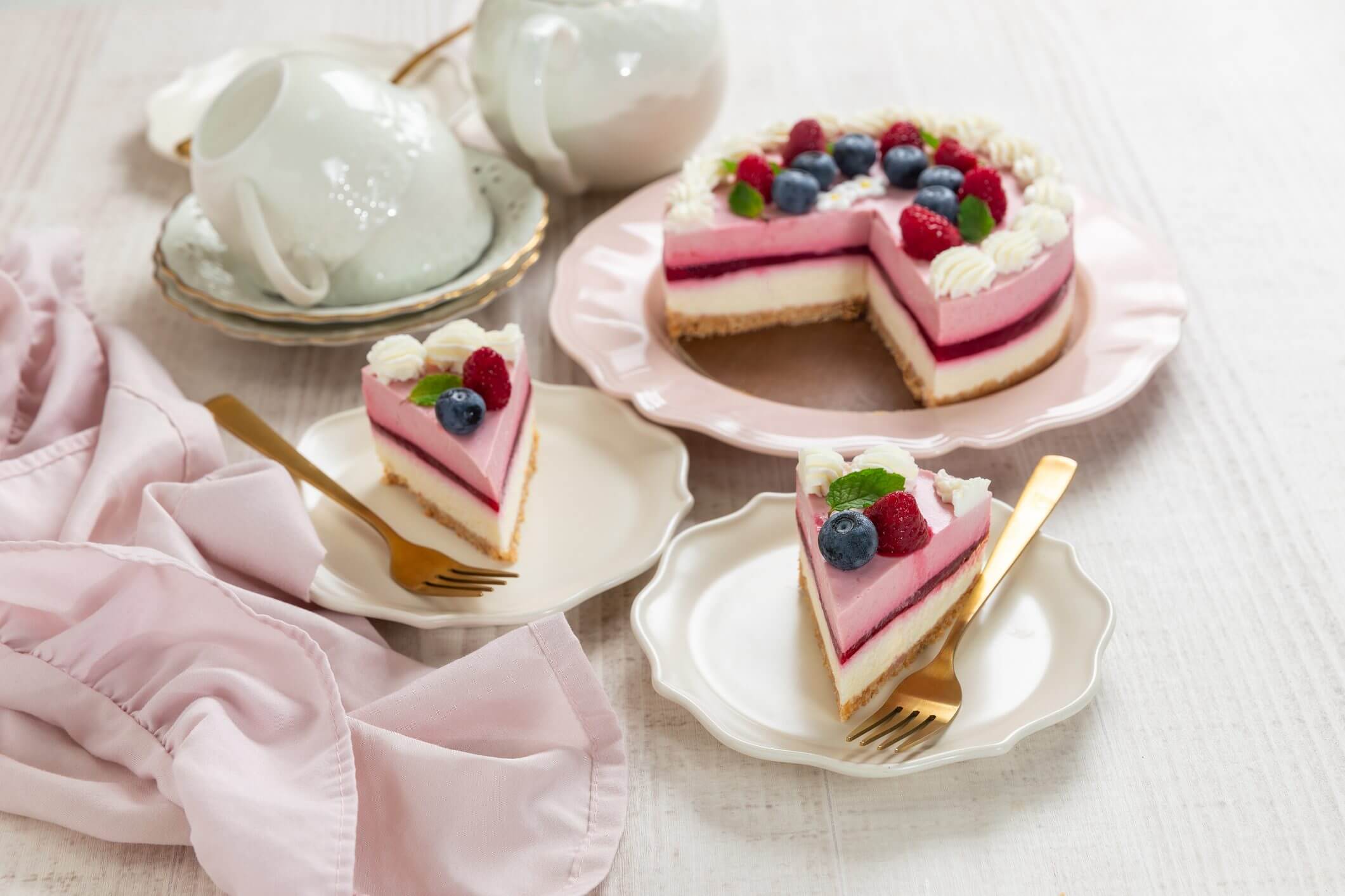 Pink cake with berries and tea set.