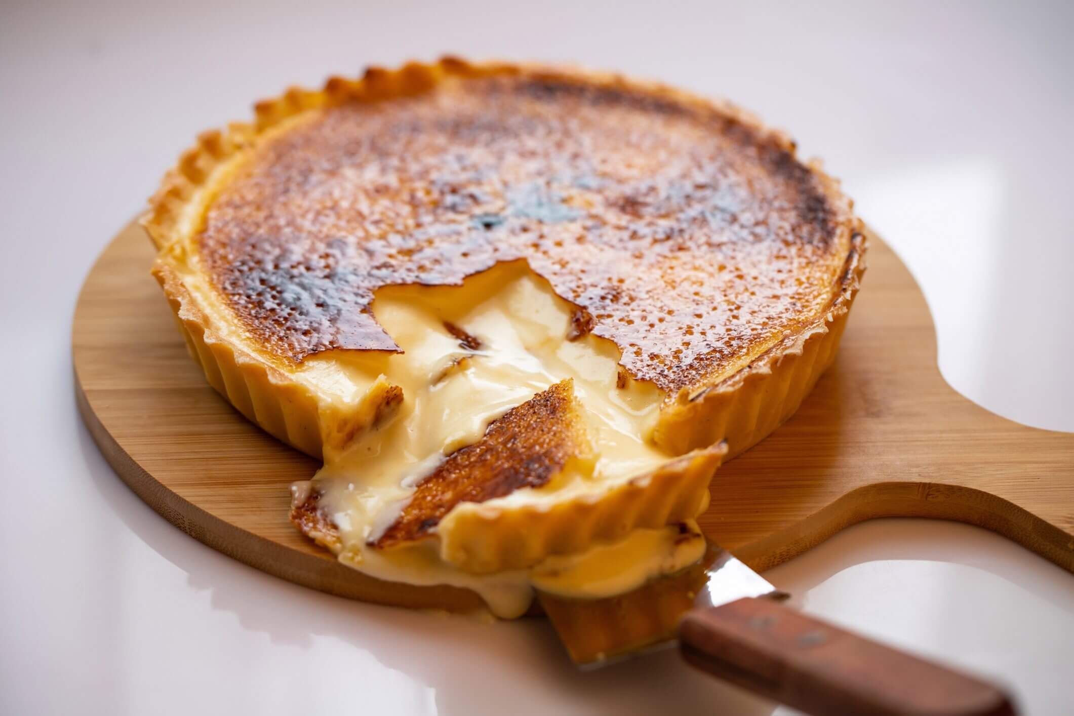 Melted cheese tart on wooden board.